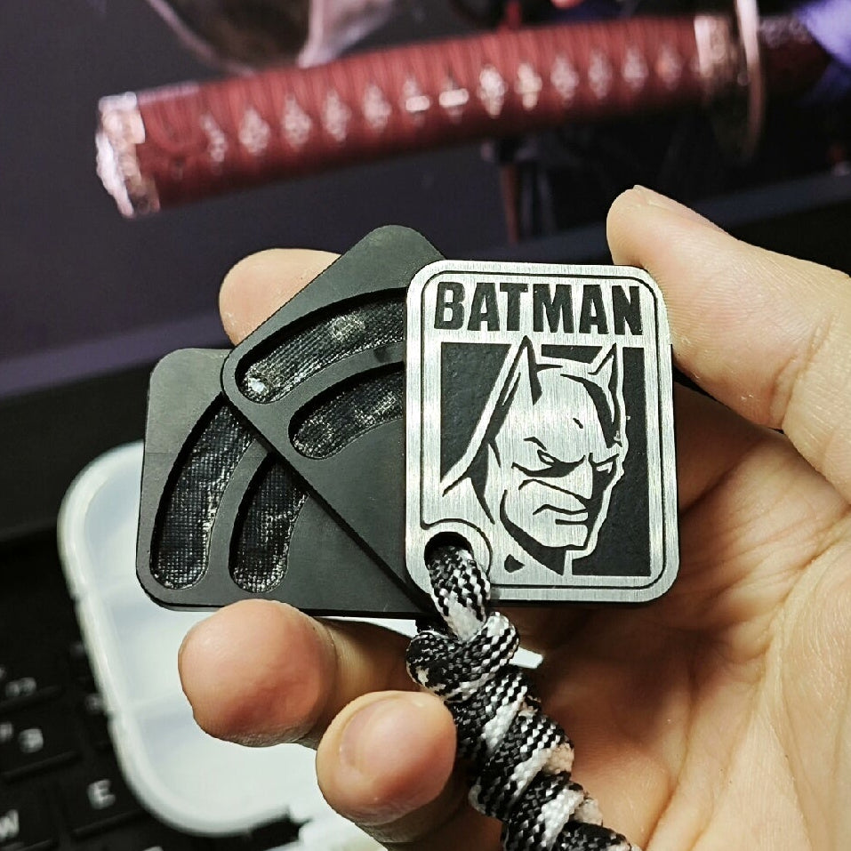 Black Batman-themed metal fidget slider held in hand